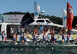 La plantilla titular de Arraun Lagunak ondea la Bandera de Ondarroa como celebración de la victoria y el título de liga.