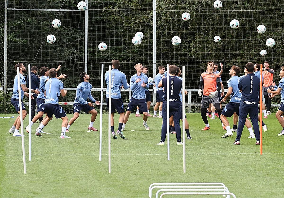 Los jugadores de la Real lanzan los balones al aire en un ejercicio en la sesión de entrenamiento de ayer en el Z2.