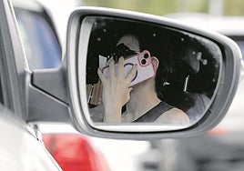 Una mujer habla por el teléfono móvil mientras conduce en Irun.