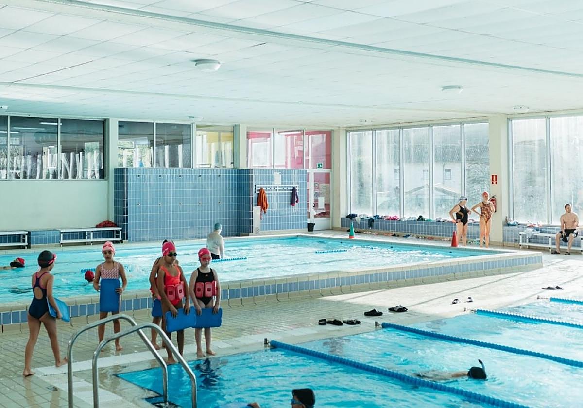Un grupo de niñas y niños asiste a una clase de natación en las piscinas de Musakola.