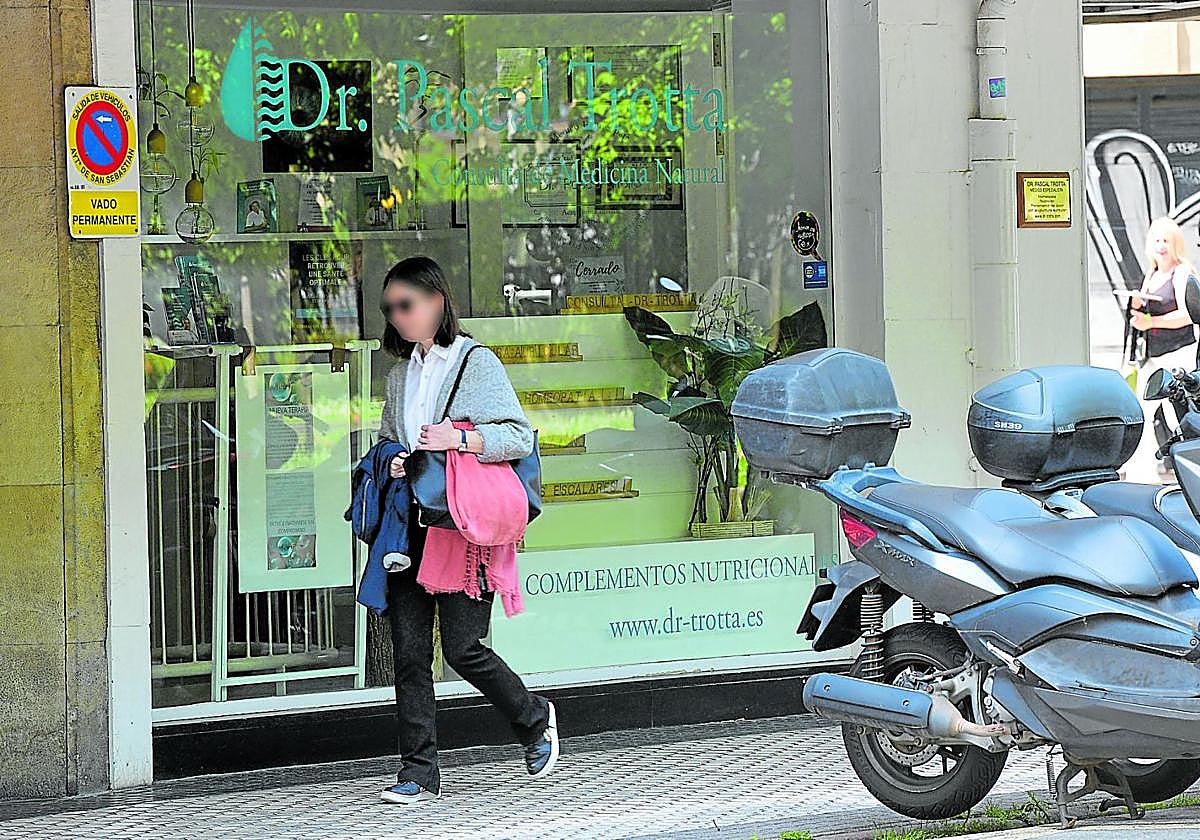 Una mujer pasa junto a la consulta de homeopatía de Pascal Trotta, el doctor que ha sido condenado en Francia, en el centro de Donostia.