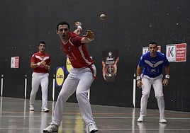 Altuna III se dispone a golpear la pelota ante la atenta mirada de Jaka y Eskiroz, al fondo.