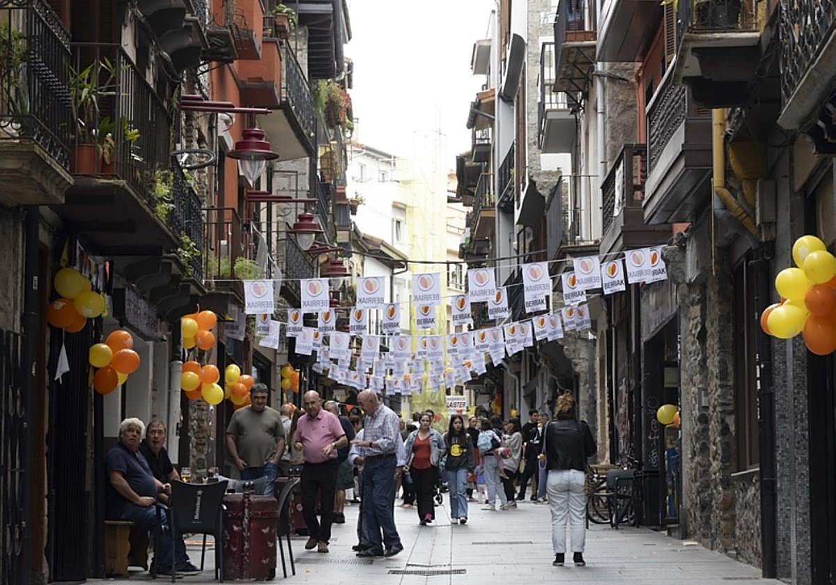 Participantes en el homenaje, mercado en Plaza Berri y calle del Casco Histórico engalanada por la Fiesta del Comercio.