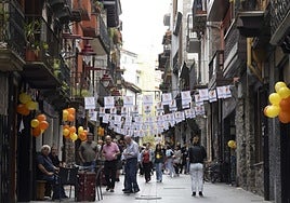 Participantes en el homenaje, mercado en Plaza Berri y calle del Casco Histórico engalanada por la Fiesta del Comercio.