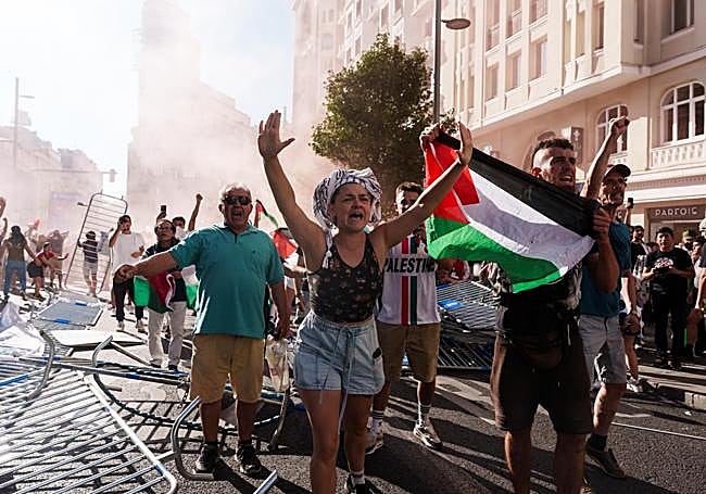 Varias personas con banderas de Palestina irrumpen la Gran Vía antes de pasar la etapa 21 de la Vuelta Ciclista a España en Madrid