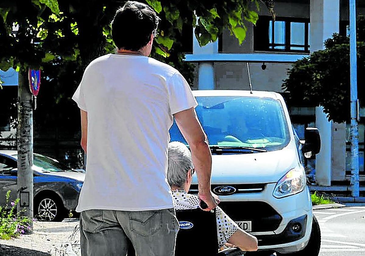 Un familiar pasea a una residente en el entorno de Txara I, en el barrio donostiarra de Intxaurrondo.