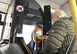 Una persona ajena a esta información pasa su Mugi por una validadora de un autobús.