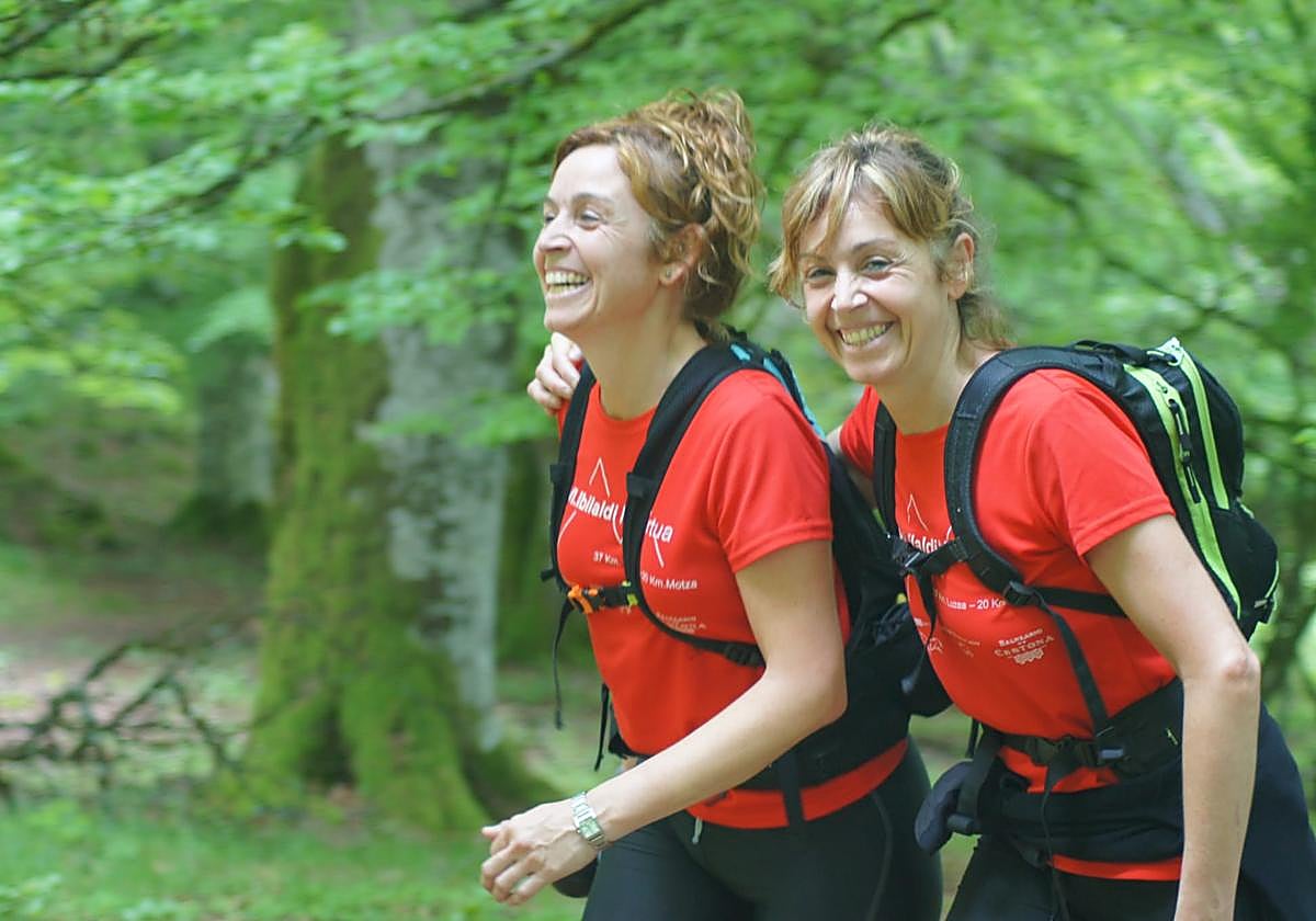 Dos mujeres participan en un marcha de montaña regulada.