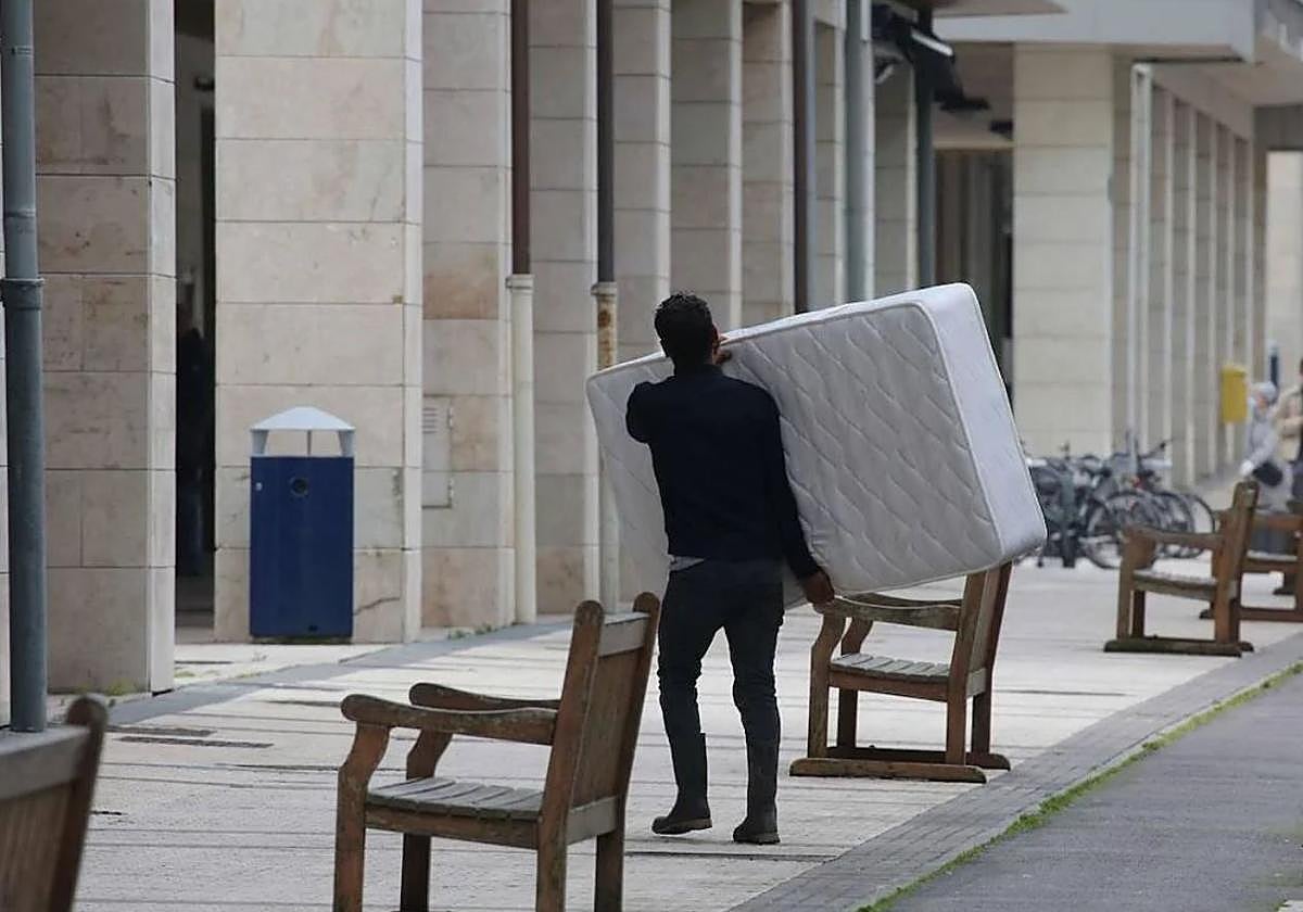 Un hombre lleva un colchón a un domicilio.