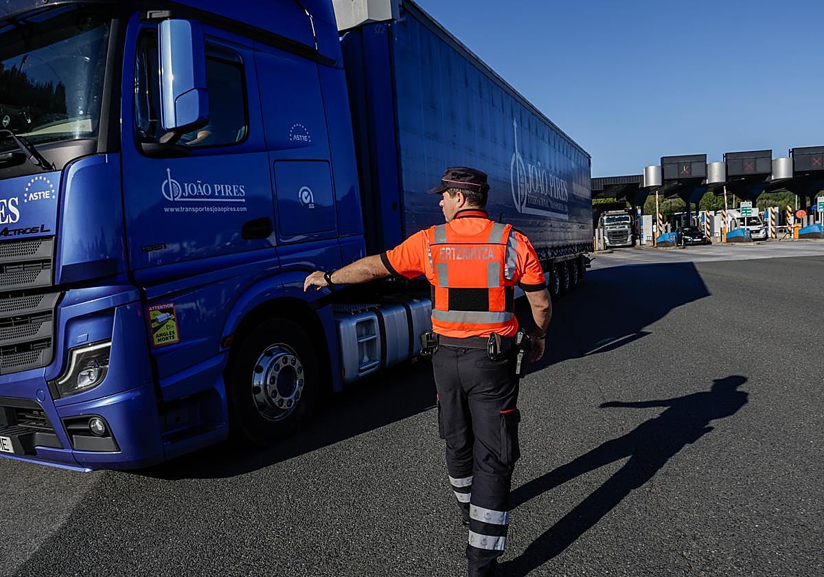 Un ertzaina da el alto a un camión en el marco de las pruebas de control de emisiones que se llevan a cabo en el peaje de Irun.