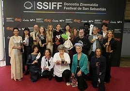 Los participantes del original desfile con las botellas solidarias en la alfombra roja fuera del Kursaal.