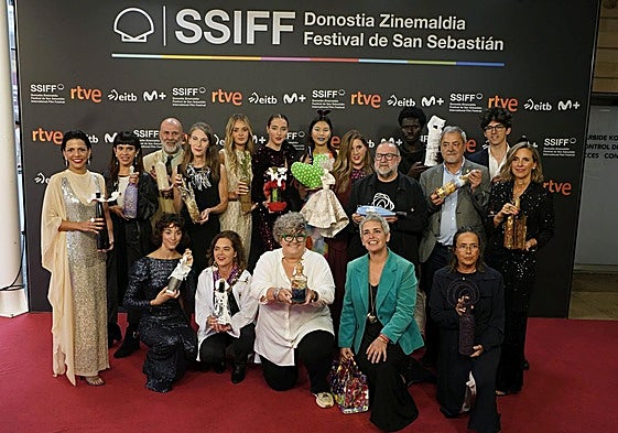 Los participantes del original desfile con las botellas solidarias en la alfombra roja fuera del Kursaal.