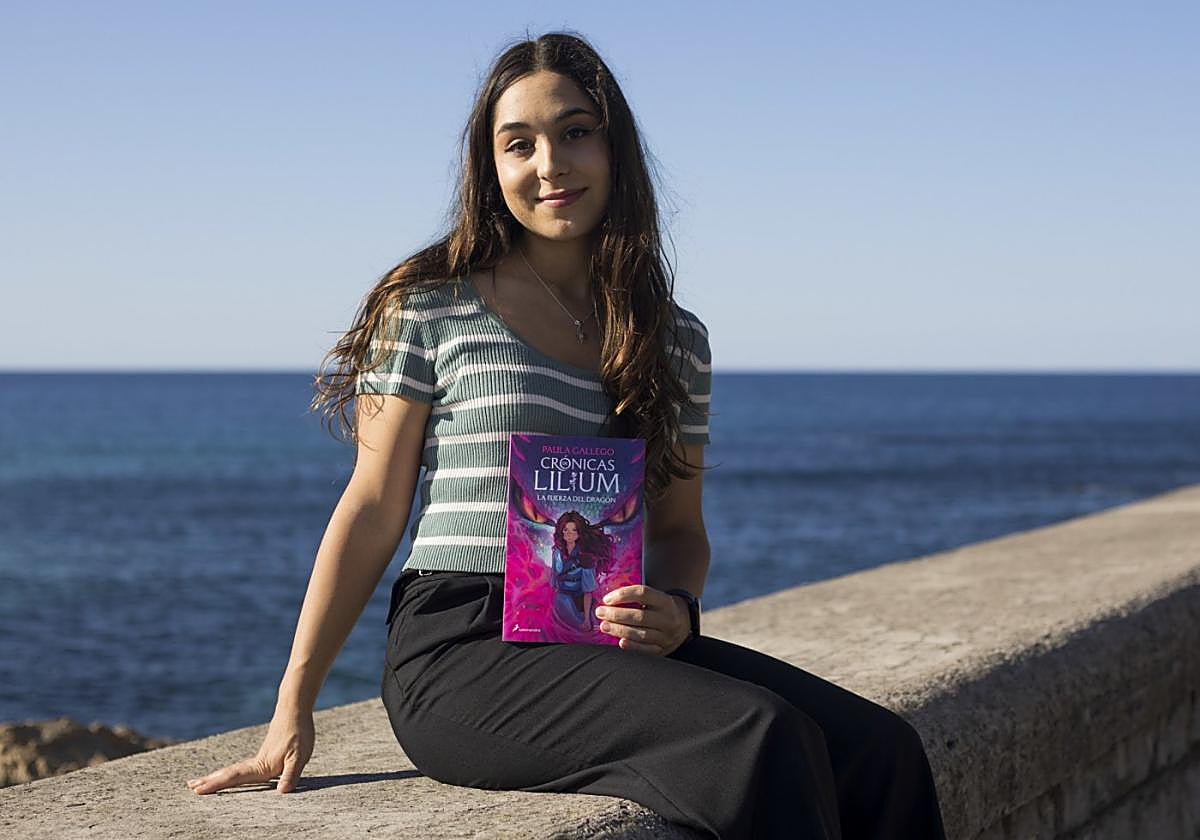 Paula, con un ejemplar de 'La fuerza del dragón', paseando (y posando) desde Sagüés hasta el Muelle.