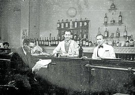 Camareros y cliente en un bar.