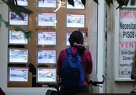 Una joven mira los anuncios de una inmobiliaria de Donostia.