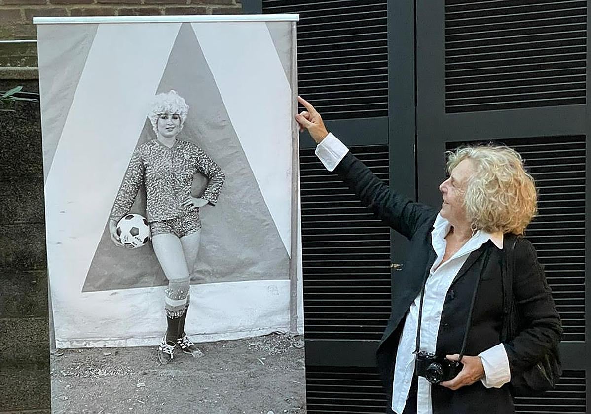 Azkarate, con su inseparable cámara, junto al cartel de la exposición.