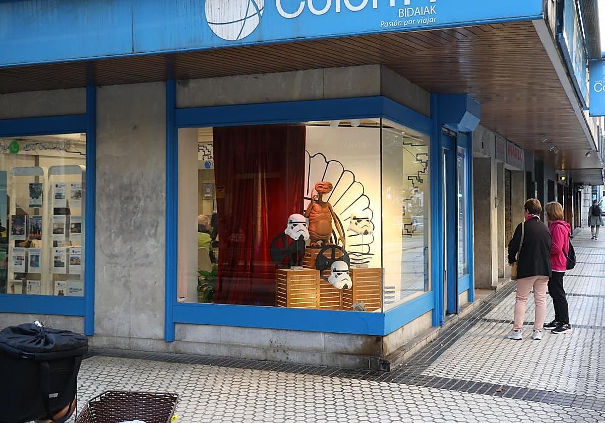 Dos mujeres consultan las propuestas de viaje en el escaparate de una agencia de viajes de San Sebastián.