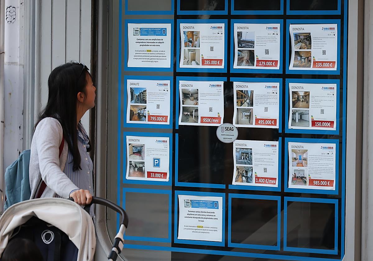 Una mujer consulta los anuncios de una inmobiliaria de Donostia.