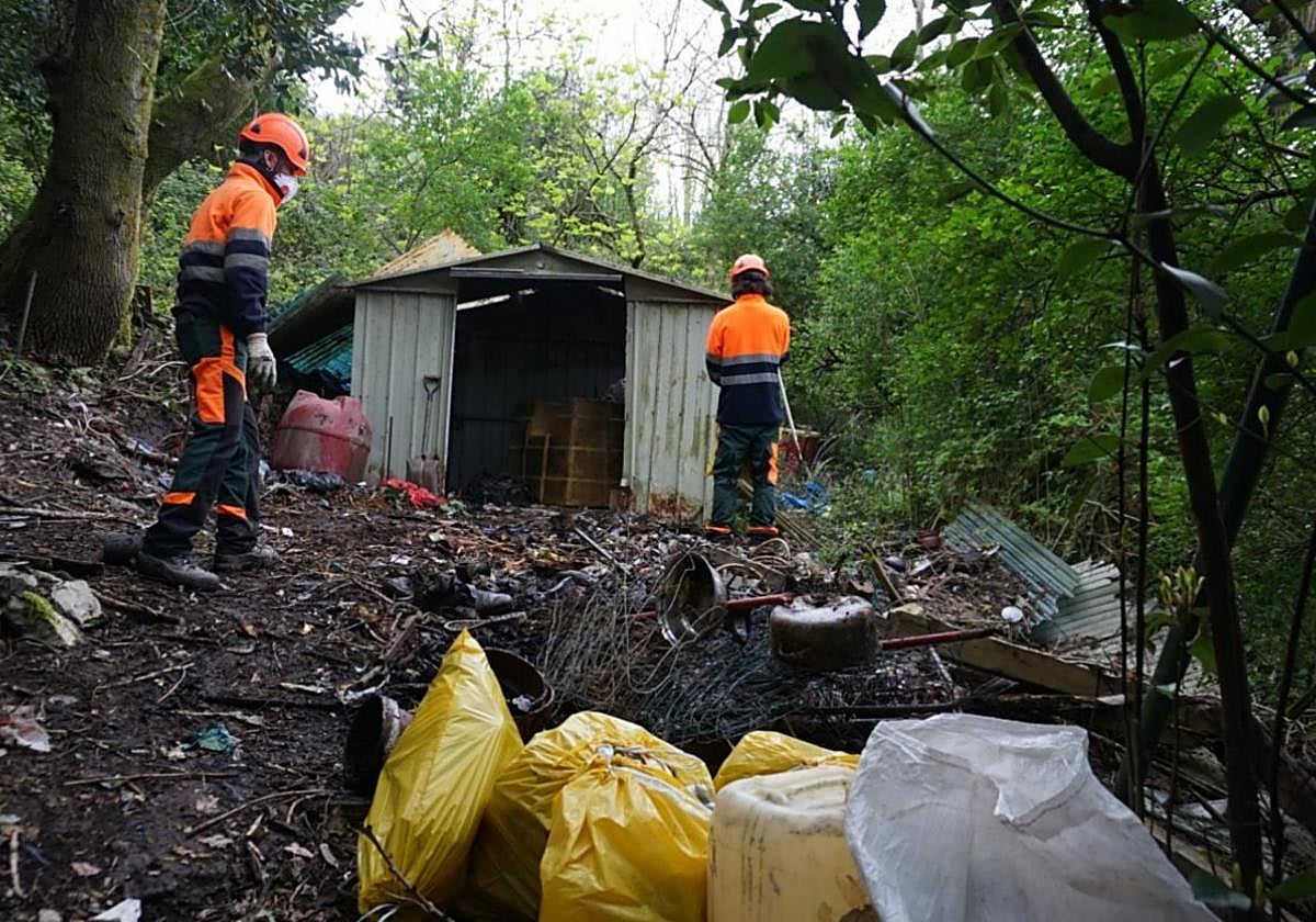 Dos operarios de Urzain Taldea llevando a cabo labores de limpieza en la zona próxima al parque de Altamira.