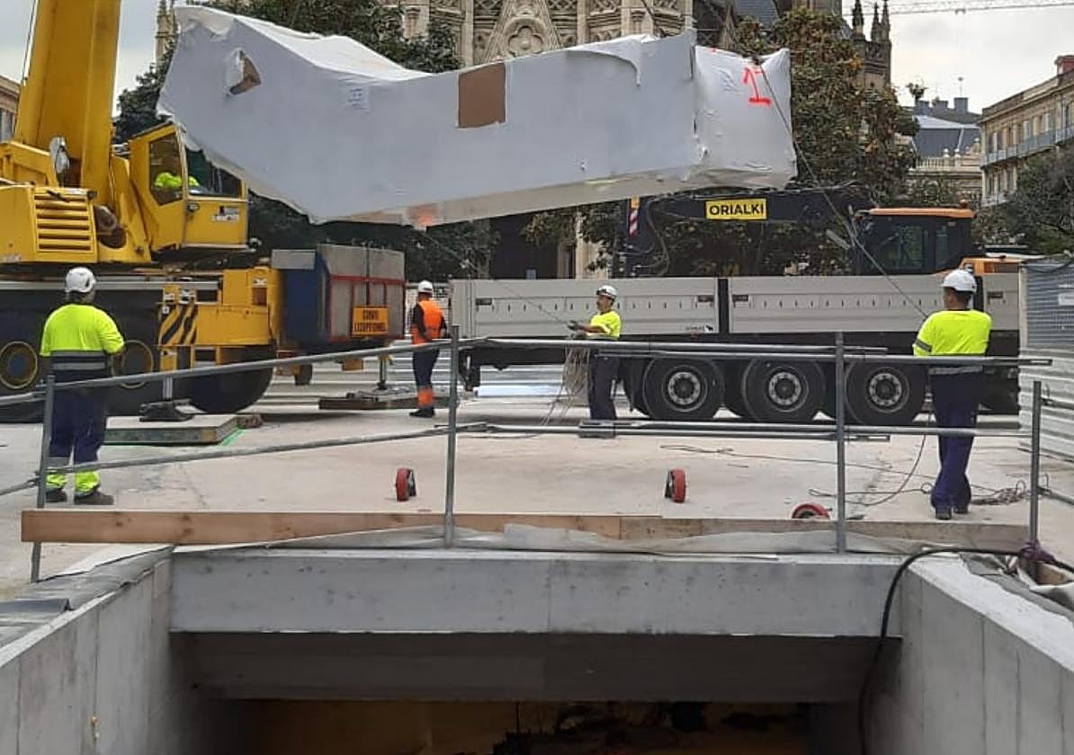 Una grúa descarga una sección de las escaleras mecánicas junto a la boca de acceso de la calle Loiola.