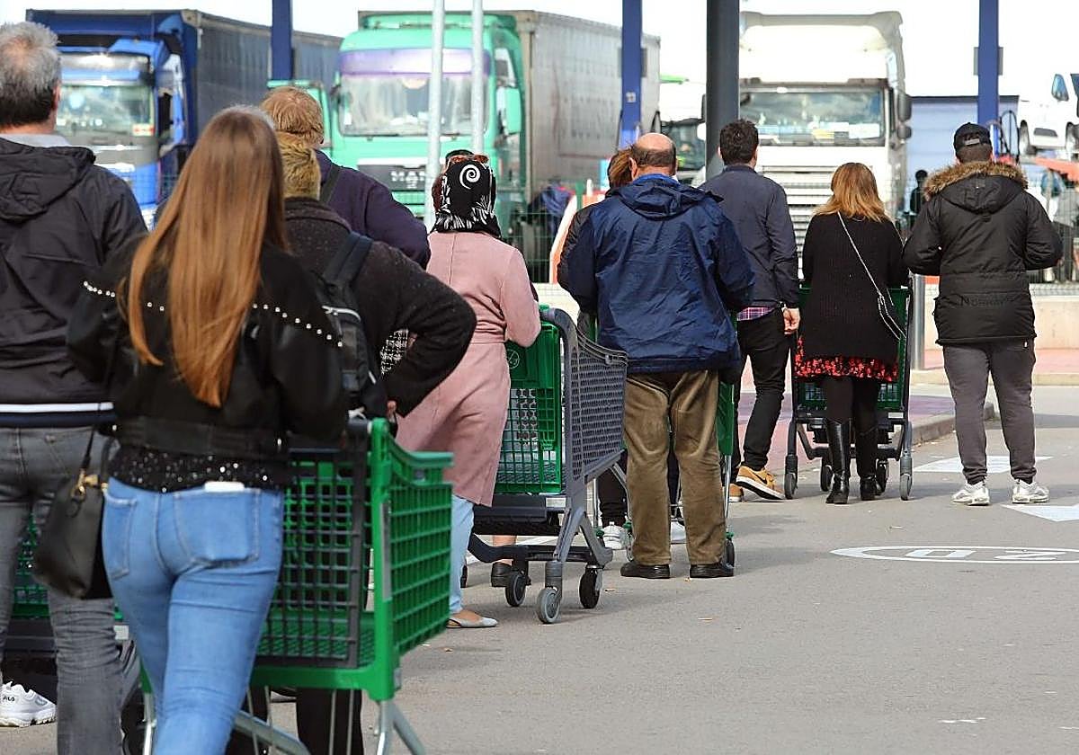 Fila de clientes a las puertas de un supermercado.