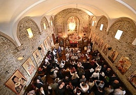 Fieles ortodoxos en la ermita de Uba de Martutene, mientras un coro de niños canta el himno de Rumanía frente al altar.