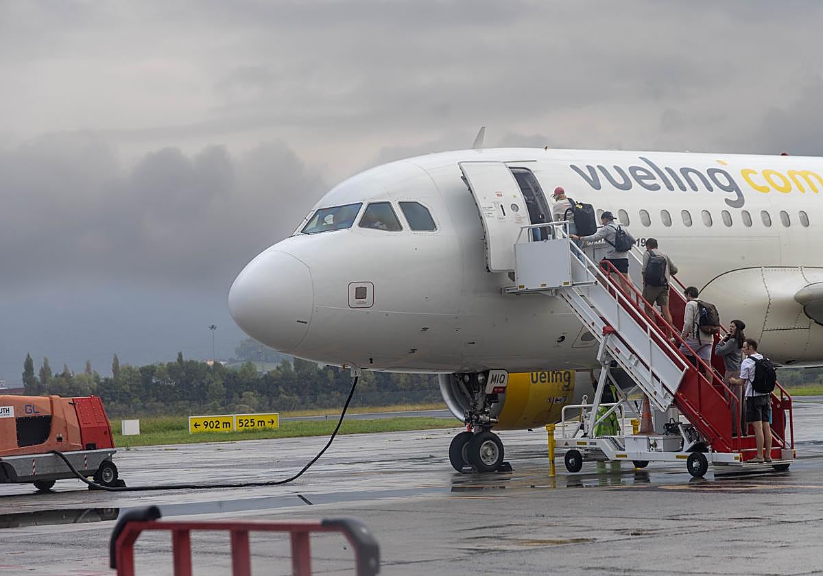 Pasajeros se suben a un avión de Vueling con destino a Barcelona en la pista de Hondarribia.