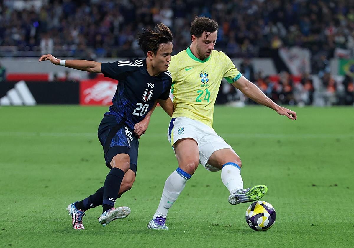 Take Kubo trata de arrebatar el cuero a Carlos Augusto en el amistoso de Japón ante Brasil en Tokio