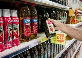 Una persona compra aceite en un supermercado.