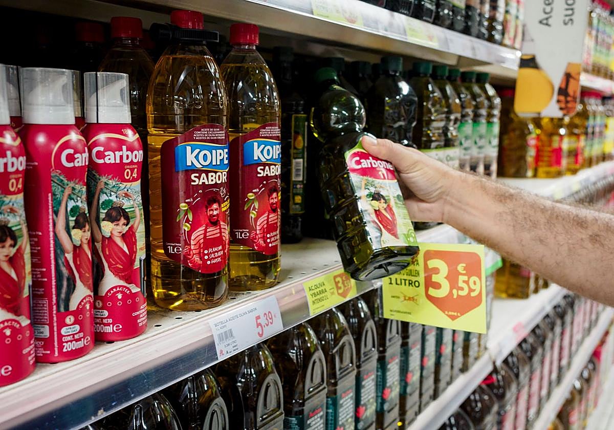 Una persona compra aceite en un supermercado.