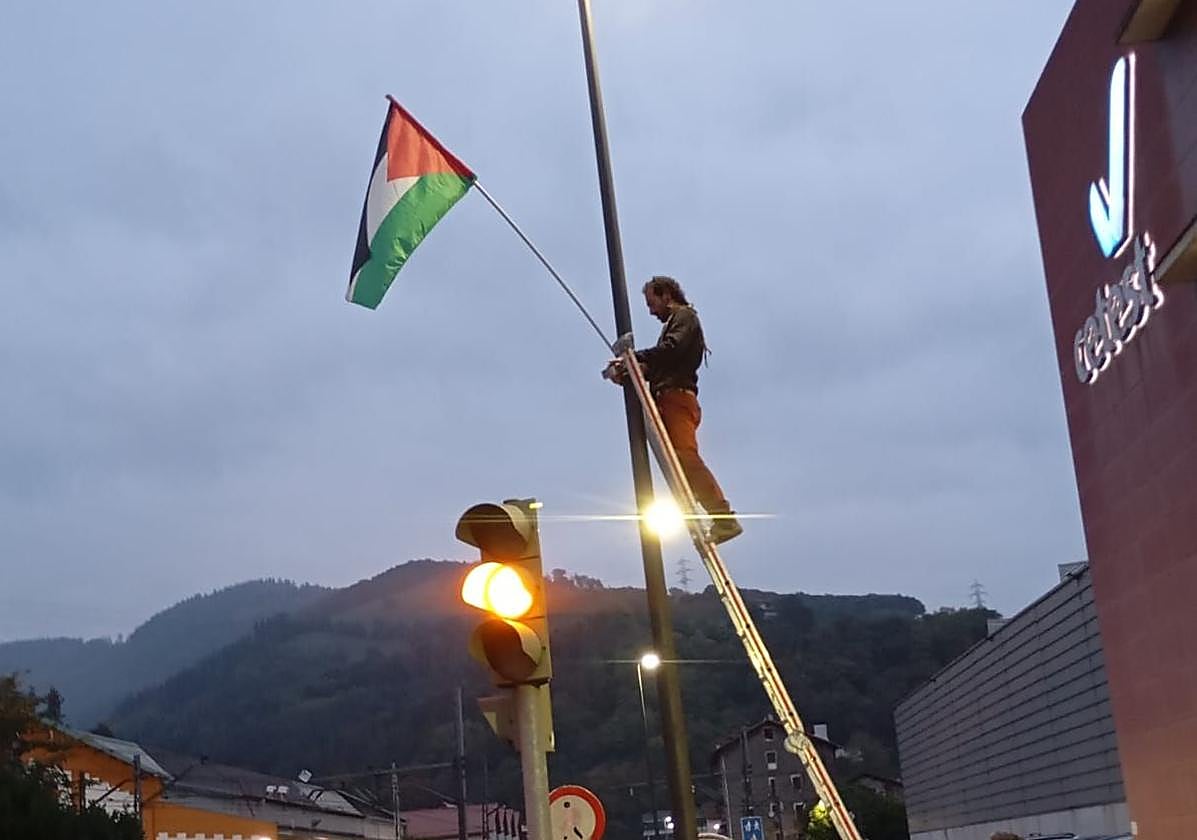 Miembros del sindicato LAB colocan una bandera de Palestina la madrugada del 15 de octubre cerca de la sede de CAF.