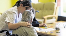 Una trabajadora atiende a una persona mayor en una residencia.