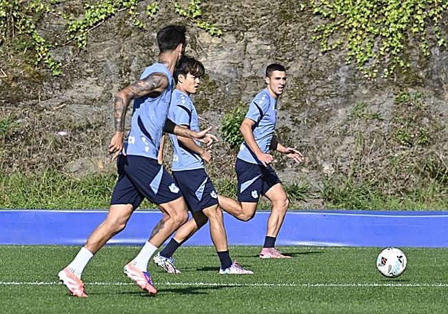 Kubo golpea el cuero entre Brais y Karrikaburu en el entrenamiento de este viernes
