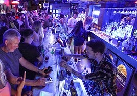 Barra de un bar lleno de clientes.