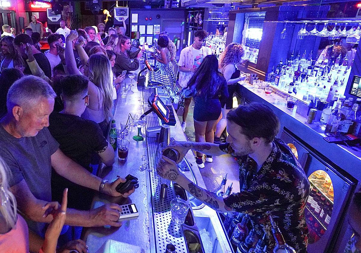 Barra de un bar lleno de clientes.