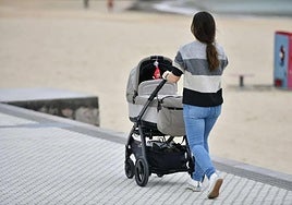 Una mujer pasea junto a su bebé en Ondarreta