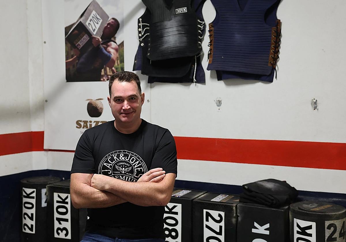 Inaxio Perurena, rodeado de sus grandes piedras y chalecos en su gimnasio de Leitza.