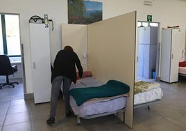 Una trabajadora de Cáritas Gipuzkoa acomoda una cama en el centro nocturno Hotzaldi.