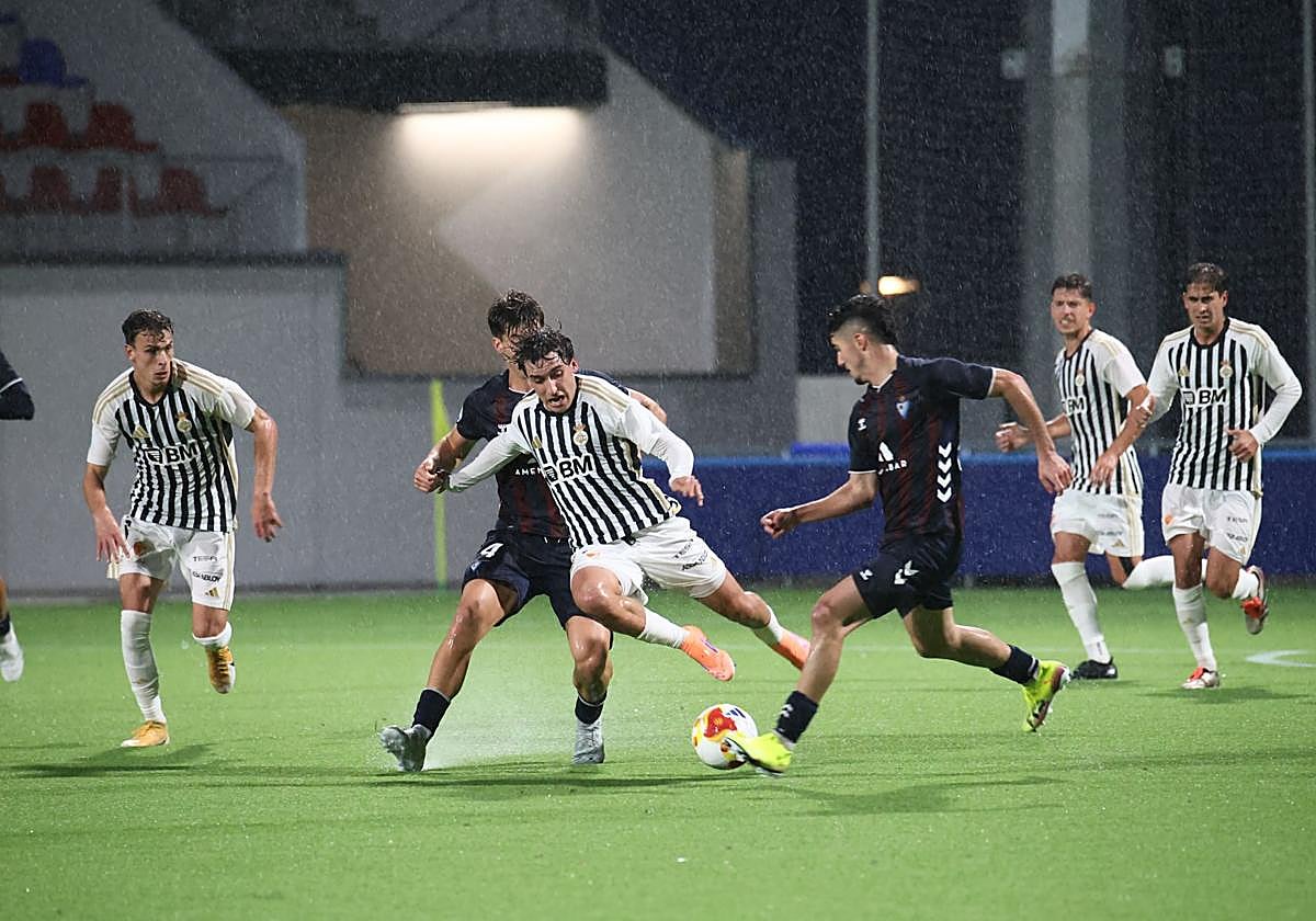 Arruti trata de zafarse de la presión del Eibar bajo la lluvia del Areitio.