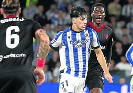 Jon Martín conduce el balón por delante de Agoumé, ayer en Anoeta.