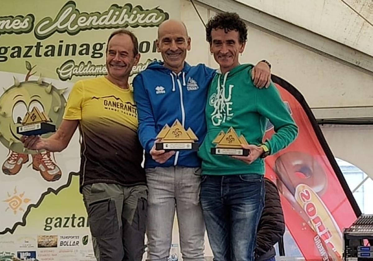 Jexux Zelaia, podioan, lehiakideekin eta saria eskuetan duela.