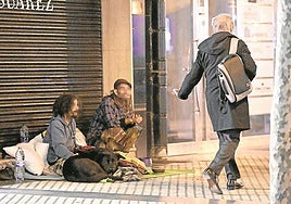 Dos personas 'sintecho' piden limosna en las calles de Donostia.