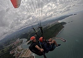 Dos parapentistas volando por la zona de Orio, disfrutando de la experiencia y de las vistas.