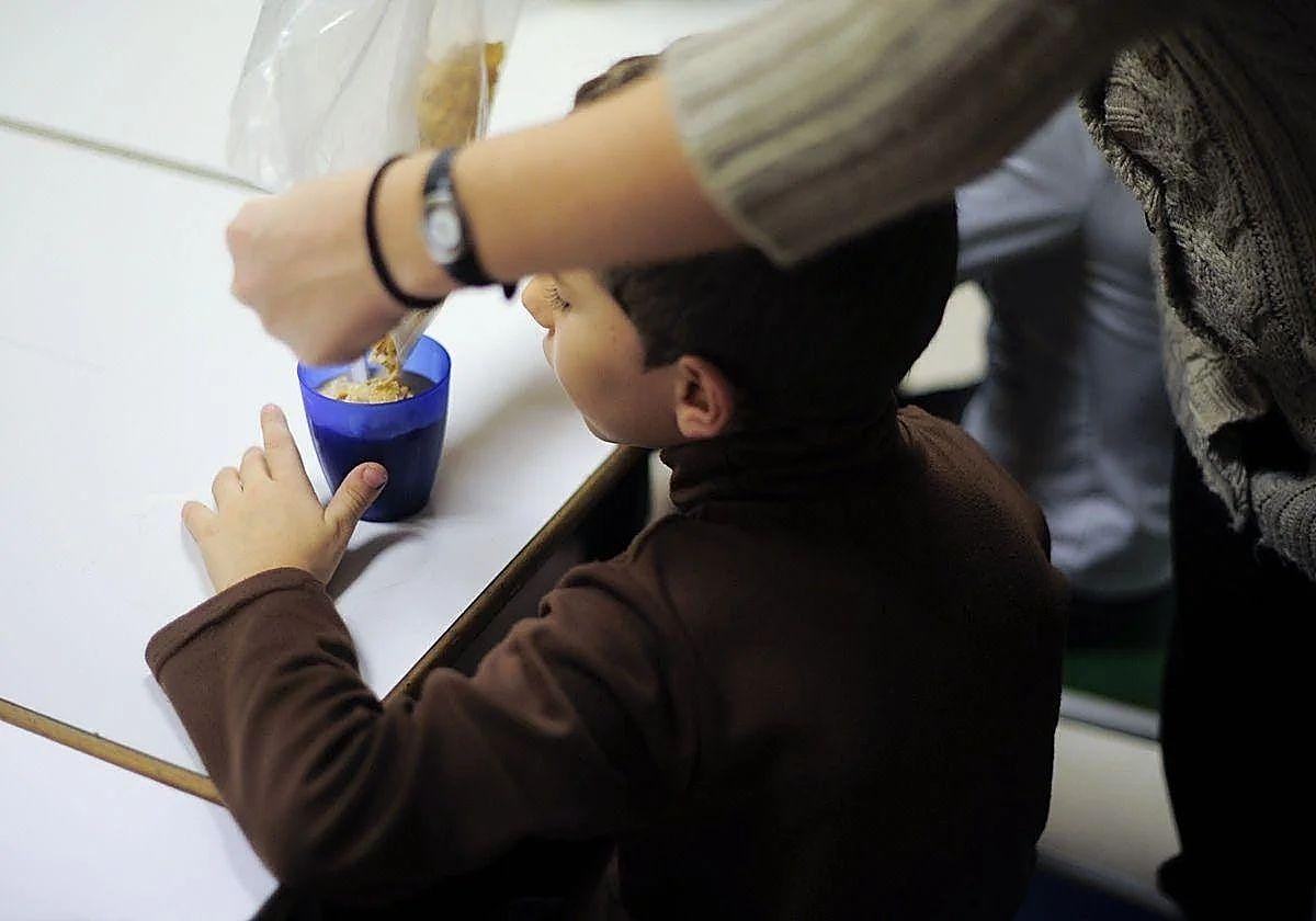 Un niño con bajos recursos toma la merienda en el local de una ONG.