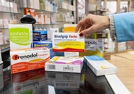 Medicamentos contra la gripe y la tos en una farmacia.