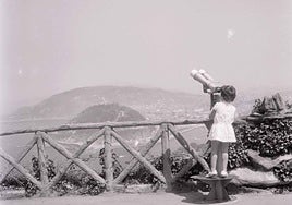 Una niña se dispone a observar con catalejos desde el monte Igeldo.
