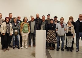 Foto grupal durante la exposición 'Iñaki Olazabal bidean', con una obra del artista.