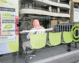 Una mujer de ascendencia árabe espera en un servicio de lavado de ropa en Ordizia.