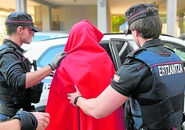 Dos ertzainas trasladan a un detenido a los juzgados de Donostia.