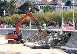 La excavadora taponó ayer los huecos en la escollera y hoy retirará los restos de las escaleras de Ondarreta.